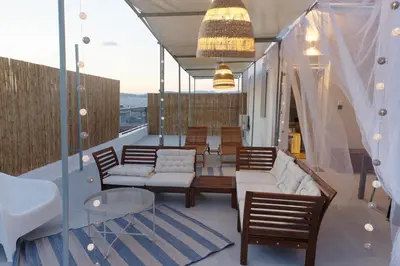 a balcony with a couch and chairs and a table at Rooftop studio with private terrace at Lycabettus Hill in Athens