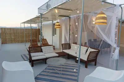 a patio with four chairs and a table and a glass house at Rooftop studio with private terrace at Lycabettus Hill in Athens