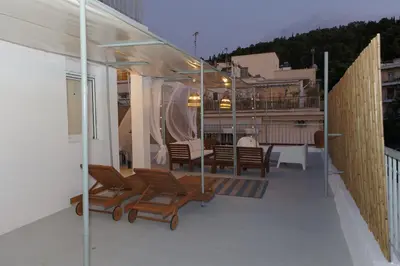a balcony with chairs and tables on a house at Rooftop studio with private terrace at Lycabettus Hill in Athens
