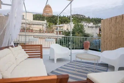 a living room with a couch and a table on a balcony at Rooftop studio with private terrace at Lycabettus Hill in Athens