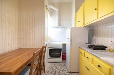 a kitchen with a table and a white refrigerator at Acropolis Athens 1 bedroom 4 pers apt by MPS in Athens