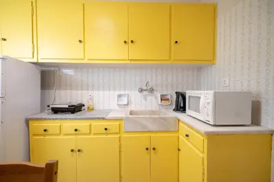 a yellow kitchen with a microwave and a sink at Acropolis Athens 1 bedroom 4 pers apt by MPS in Athens