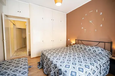 a bedroom with a bed and a clock on the wall at Acropolis Athens 1 bedroom 4 pers apt by MPS in Athens