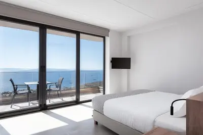 a bedroom with a bed and a view of the ocean at Saronida Hills in Saronida