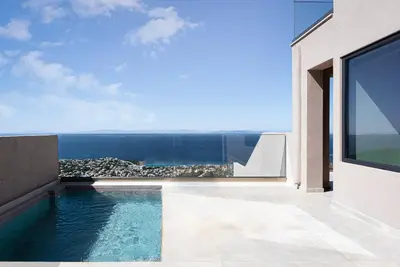 a swimming pool on the side of a house at Saronida Hills in Saronida