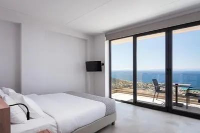 a bedroom with a bed and a view of the ocean at Saronida Hills in Saronida