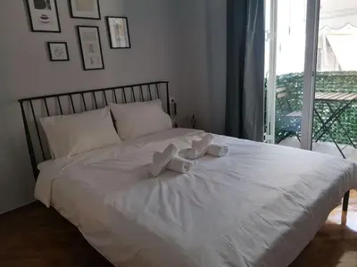 a white bed with two teddy bears on it at Minimal Studio Varnava Square - Kallimarmaro Area in Athens