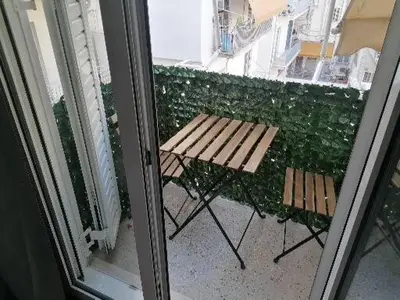 a balcony with a table and bench on a balcony at Minimal Studio Varnava Square - Kallimarmaro Area in Athens