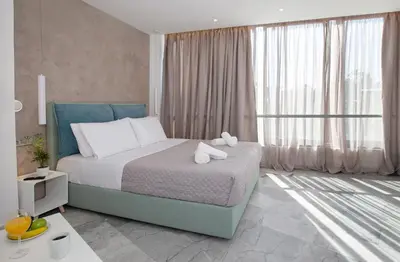 a bedroom with a bed and a large window at Iconic Athens Suites in Athens