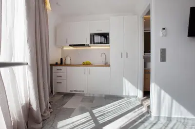 a kitchen with white cabinets and a counter top at Iconic Athens Suites in Athens