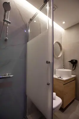 a bathroom with a shower with a toilet and a sink at Iconic Athens Suites in Athens