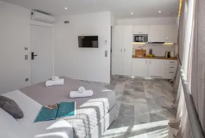 a bedroom with two beds with towels and a kitchen at Iconic Athens Suites in Athens