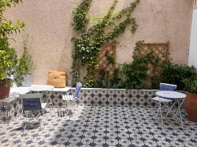 a patio with two tables and chairs and plants at Iconic Athens Suites in Athens