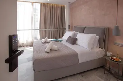 a bedroom with a large bed with towels on it at Iconic Athens Suites in Athens