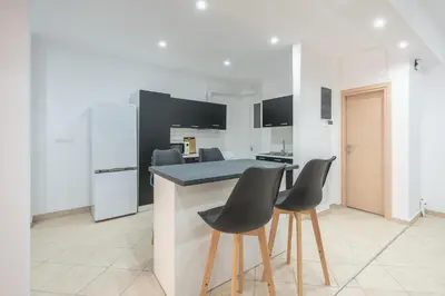 a kitchen with a island with chairs and a counter top at ATHENIAN HOME Near Acropolis in Athens