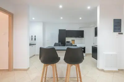 a kitchen with a table and two black chairs at ATHENIAN HOME Near Acropolis in Athens