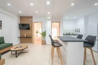 a kitchen and living room with a counter and chairs at ATHENIAN HOME Near Acropolis in Athens
