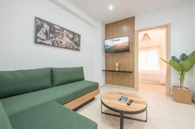 a living room with a green couch and a table at ATHENIAN HOME Near Acropolis in Athens