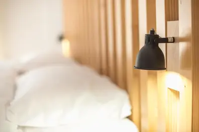 a lamp hanging on a wall next to a bed at ATHENIAN HOME Near Acropolis in Athens