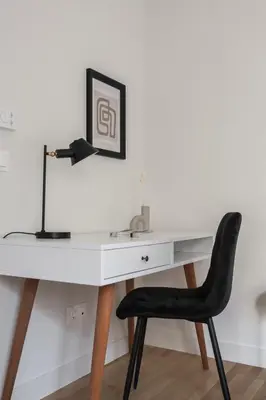 a white desk with a black chair and a lamp at Spectacular 3BR Apartment in Pangrati by UPSTREET in Athens
