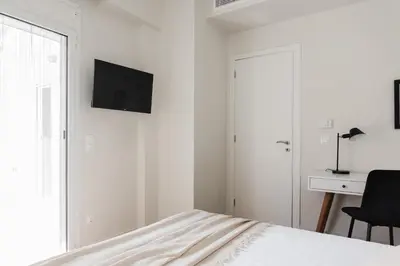 a bedroom with a bed with a television on the wall at Spectacular 3BR Apartment in Pangrati by UPSTREET in Athens
