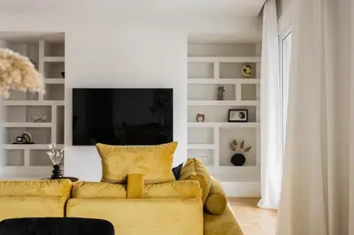 a living room with a yellow couch and a tv at Spectacular 3BR Apartment in Pangrati by UPSTREET in Athens
