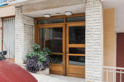 a wooden door on a building with a car in it at Spectacular 3BR Apartment in Pangrati by UPSTREET in Athens