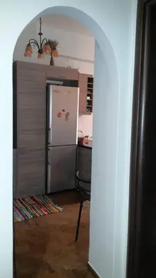 a kitchen with a refrigerator and a table with a chair at Κεντρικό διαμερισμα άνετο κ ήσυχο in Athens