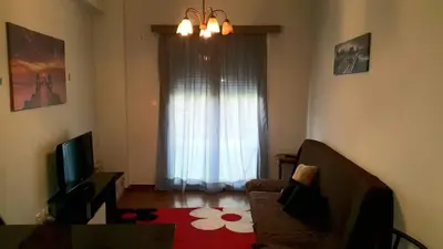 a living room with a television and a window at Κεντρικό διαμερισμα άνετο κ ήσυχο in Athens
