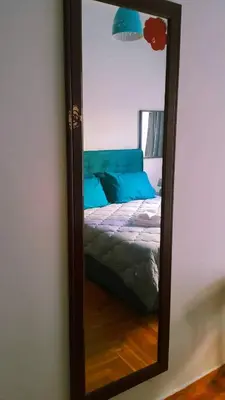 a mirror on a wall with a bed in a room at Κεντρικό διαμερισμα άνετο κ ήσυχο in Athens