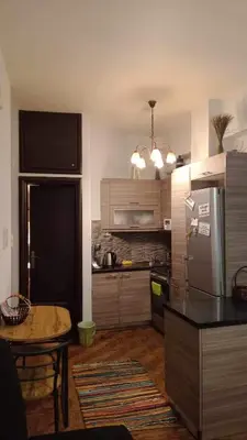 a kitchen with a stainless steel refrigerator and a table at Κεντρικό διαμερισμα άνετο κ ήσυχο in Athens