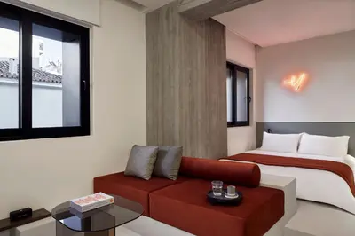 a bedroom with a bed and a red couch at The Newel Metaxourgeio by Athens Stay in Athens