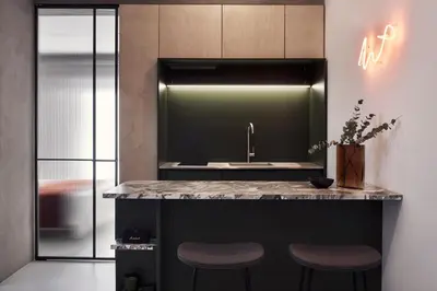 a kitchen with a counter with two stools and a sink at The Newel Metaxourgeio by Athens Stay in Athens
