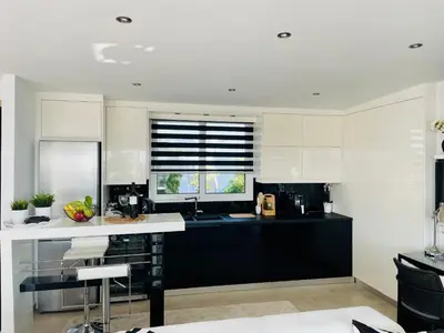 a kitchen with black and white cabinets and a window at Luxury Penthouse Studio with Sea View, Palaio Faliro in Athens