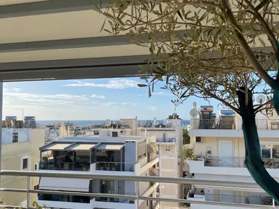 a view of a city from the balcony of a building at Luxury Penthouse Studio with Sea View, Palaio Faliro in Athens