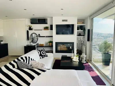 a living room with a white couch and a fireplace at Luxury Penthouse Studio with Sea View, Palaio Faliro in Athens