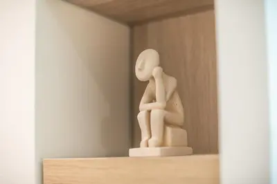 a figurine of a person sitting on a shelf at SYNTAGMA MINI in Athens