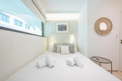 a bedroom with a white bed with white pillows at SYNTAGMA MINI in Athens