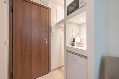 a hallway with a wooden door and a washer and dryer at SYNTAGMA MINI in Athens