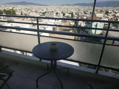 a table on a balcony with a view of a city at Athens view apartment near Metro station Agia Marina in Athens