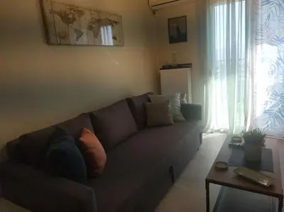 a living room with a couch and a table at Athens view apartment near Metro station Agia Marina in Athens