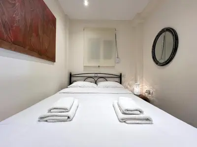 a bedroom with a white bed with towels on it at Historic Center getaway 10'walk to Acropolis hill in Athens
