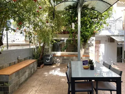 a patio with a table and benches and trees at Historic Center getaway 10'walk to Acropolis hill in Athens