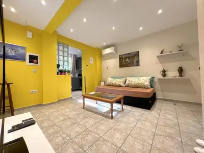 a living room with yellow walls and a couch at Historic Center getaway 10'walk to Acropolis hill in Athens