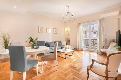 a living room with a table and chairs and a couch at Stylish King size bed apt steps from Acropolis by GHH in Athens