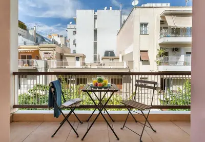a balcony with two chairs and a table with fruit on it at Stylish King size bed apt steps from Acropolis by GHH in Athens