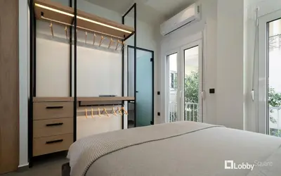 a master bedroom with a bed and a closet at La Mer Apartment by LobbySquare in Piraeus