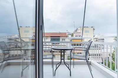 a table and chairs on a balcony with a view at Comfy Sweet Home in Athens
