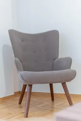 a grey chair with wooden legs in a room at Comfy Sweet Home in Athens