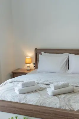a bed with two white towels on top of it at Comfy Sweet Home in Athens
